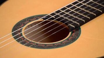 Detail of mouth, strings, frets, body of spanish classic guitar rotating video