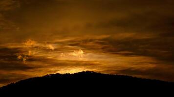 Time lapse of the sun rising over hills that are covered with clouds, in the style of smokey background. video