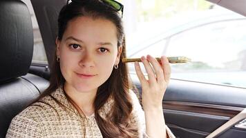 Young woman listening to voice message from mobile phone inside the car. High quality 4k footage video