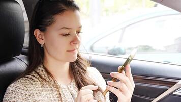 ung kvinna sändning en röst meddelande med mobil telefon inuti de bil. hög kvalitet 4k antal fot video
