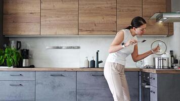 tempo periodo metraggio di un' donna danza e cantando mentre preparazione la minestra nel sua casa cucina e utilizzando vario cucina utensili. alto qualità 4k metraggio video