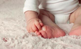 manos y pies cerca arriba de un bebé. foto