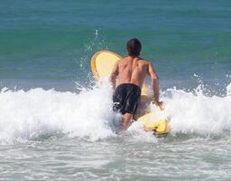 Surfer on longboard rides a wave in the sea photo