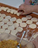 On the wooden counter top Woman hands are making a damp dumpling photo