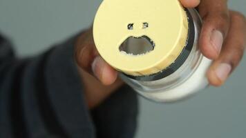 persoon houdt blauw zout shaker met verdrietig gezicht video