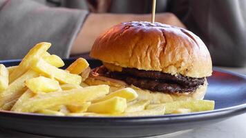 hand holding beef burger on table close up video