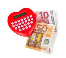 Red heart shaped calculator with euro banknotes. photo