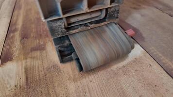 reparar trabalhos em uma de madeira chão usando uma lixadeira. horizontal do pavimentos restauração às lar. video