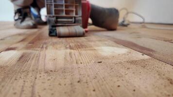 Sanding floor with grinding machine close-up . Dynamics of wooden floor restoration. Work of sander to remove old floor paint. video