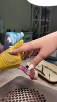 manicura en un uña salón. el uña artista formas el uñas con un uña archivo. video