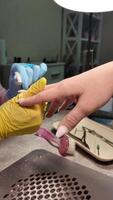 manicure dentro uma unha salão. a unha artista formas a unhas com uma unha arquivo. video