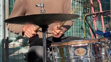 rue le batteur. de le batteurs solo. une musicien mains habilement jouer une coloré, patiné tambour sur le rue, évoquant une sens de Urbain talent artistique. video