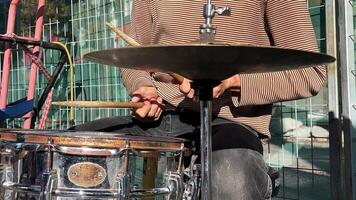 Drummer, hands skillfully maneuvering the sticks, with focus on the shiny cymbal and snare drum. video