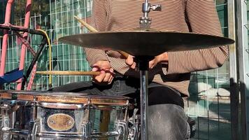 Drummer, hands skillfully maneuvering the sticks, with focus on the shiny cymbal and snare drum. video