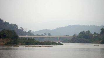 brug over- de rivier- tussen twee bergen, weg brug over- de rivier, antenne visie van een weg brug over- een rivier- toetreden een Woud Oppervlakte video