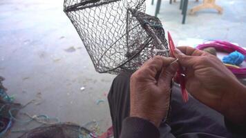 Fischer Instandsetzung Fisch fangen Korb Netz mit Netz Reparatur Nadel Filmaufnahme. video