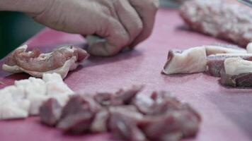 Carnicero cortes carne en su tienda imágenes. video