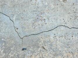 agrietado hormigón pared o la carretera superficie con gris cemento superficie como antecedentes foto