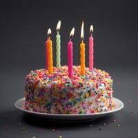 Colorful birthday cake with sprinkles and candles on a blue gray background. photo