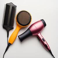 Comb brushes and hair dryer on a white background, top view photo
