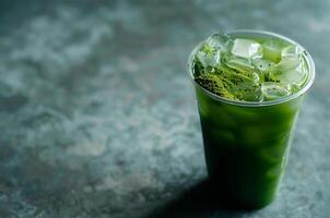 Glass of cold matcha with ice on a dark background photo