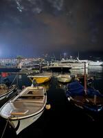 buda, montenegro - 25 diciembre 2022. pescar barcos entre yates amarrado a noche foto