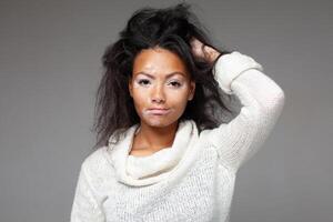 Black woman with Vitiligo disease posing with hand in hair photo