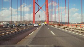 Traffic moving on 25 de Abril Bridge under cloudy sky in Lisbon video