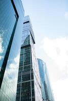 Detail blue glass building background with cloud sky photo