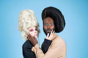 gay Pareja con Clásico pelucas y maquillaje en azul estudio foto