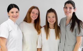 Group portrait of cosmetologists in uniform smiling at camera photo