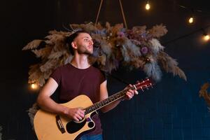 Male musician playing acoustic guitar. Guitarist plays classical guitar on stage in concert photo