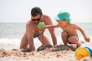 padre hijo juntos verano vacaciones jugando arena mar playa papá niño disfrute unión fin de semana actividad. foto