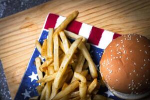 Cheese burger - American cheese burger with Golden French fries on wooden board photo