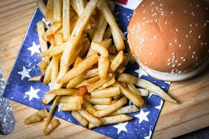 Cheese burger - American cheese burger with Golden French fries on wooden board photo