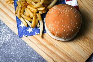 Cheese burger - American cheese burger with Golden French fries on wooden board photo