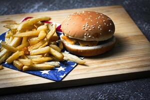 Cheese burger - American cheese burger with Golden French fries on wooden board photo