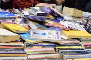 New Delhi, India, February 17 2024 - Variety of Books on shelf inside a book-stall at Delhi International Book Fair, Selection of books on display in Annual Book Fair at Bharat Mandapam complex photo