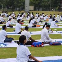 nuevo Delhi, India, junio 21, 2023 - grupo yoga ejercicio sesión para personas a yamuna Deportes complejo en Delhi en internacional yoga día, grande grupo de adultos asistiendo yoga clase en Grillo estadio foto