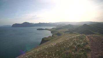 A beautiful view of a sea and mountains with a path leading to the water video