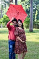 indio Pareja posando para maternidad disparar actitud para acogedor nuevo nacido bebé en lodhi jardín en Delhi India, maternidad foto disparar hecho por padres para acogedor su niño, pre bebé foto disparar