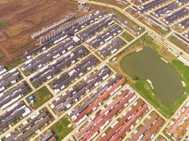 Row of houses in Bandung City from drone. Aerial drone view of public housing on the edge of the city. View from above, Housing Development. Above. Social issues. Shot from drone flying 100 meters photo