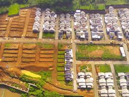 White roofed housing. Geometric aerial drone view of residential district in Bandung City - Indonesia. Housing industry. Above. Social Issues. Shot from drone flying 100 meters photo