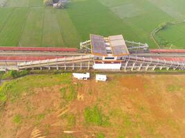 Foggy view of the Railway station. Aerial view of train track and station in Rancaekek, Bandung - Indonesia. Natural conditions. Above. Public transportation. Shot in drone flying 100 meters photo