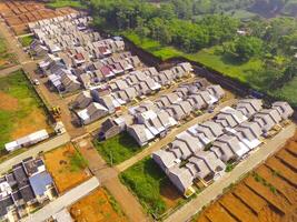 White roofed housing. Geometric aerial drone view of residential district in Bandung City - Indonesia. Housing industry. Above. Social Issues. Shot from drone flying 100 meters photo