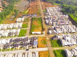 White roofed housing. Geometric aerial drone view of residential district in Bandung City - Indonesia. Housing industry. Above. Social Issues. Shot from drone flying 100 meters photo