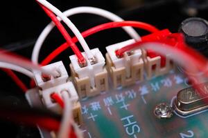 Macrophotography. Electrical closeup. Close up shot of the electrical circuit in an RC Remote Control Car. Background texture of PCB boards, cables, sockets and electronic devices. Shot with a macro photo