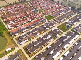 Row of houses in Bandung City from drone. Aerial drone view of public housing on the edge of the city. View from above, Housing Development. Above. Social issues. Shot from drone flying 100 meters photo