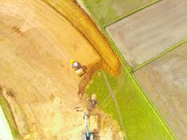 Heavy equipment vehicles are leveling the ground. Aerial drone view of Housing development on the edge of the city. View from above, Housing Industry. Above. Social issues. Shot from drone flying photo