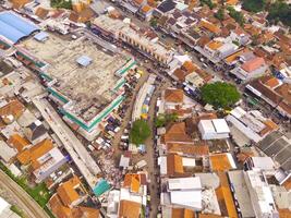 aéreo ver de principal calle de Oeste Java provincia, Indonesia. el principal la carretera en el medio de residencial áreas motos, carros y eléctrico vehículos tráfico en el principal la carretera. Disparo desde un zumbido volador foto